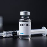 BioNTech Oncology cancer immunotherapy vial and syringe on dark premium lab background