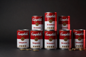 Campbell Soup Earnings Warning reflected by Campbell soup cans and snacks under dramatic lighting