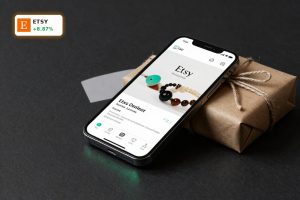 Etsy Earnings optimism shown by smartphone app and parcel symbolizing rising marketplace profits