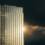Skyscraper under clearing storm clouds symbolizing strong Travelers Earnings.